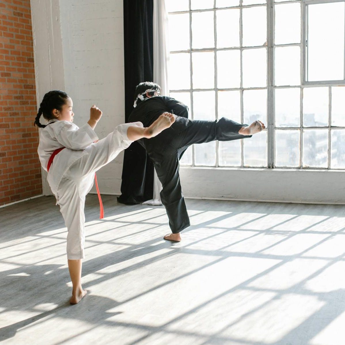 Photo of a Man and Child Practicing Taekwondo